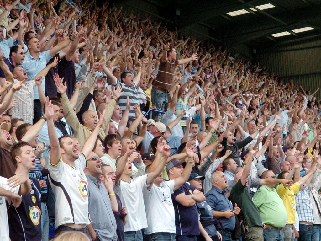 A full home end, arms aloft, mid-chant